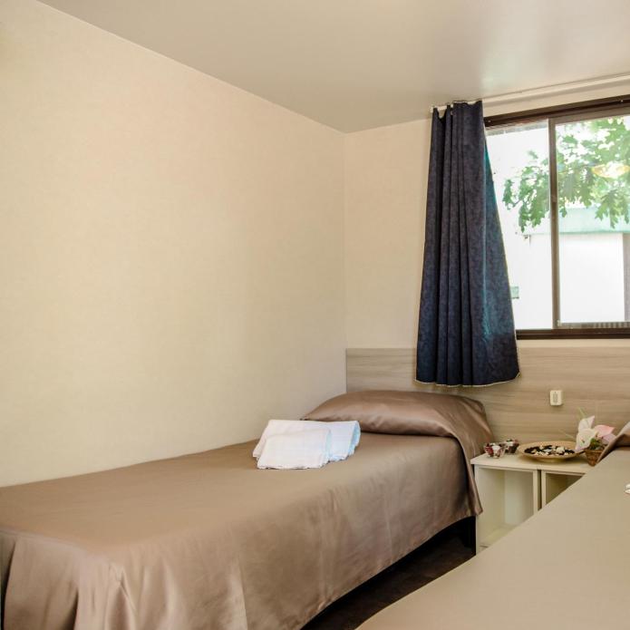 Simple room with two single beds and a window.