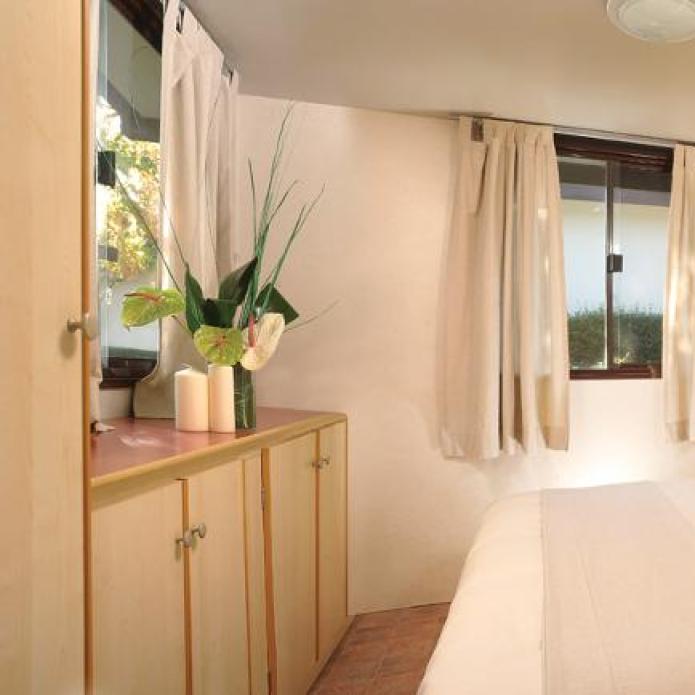 Knusse slaapkamer met natuurlijk licht en minimalistisch decor.
