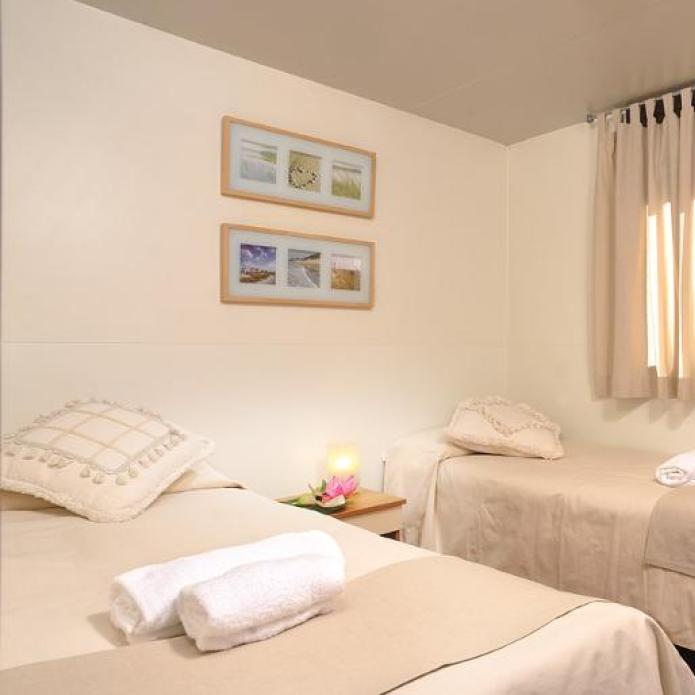 Chambre double confortable avec éclairage doux et décoration simple.